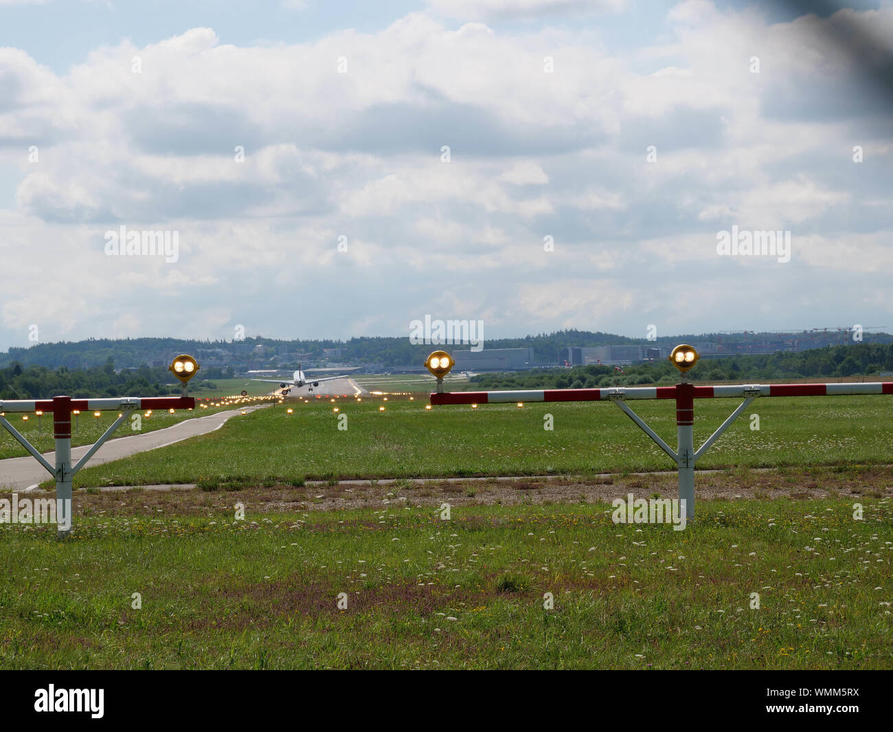 Plane landing on runway at ZRH from the end of the pist perspective Stock Photo