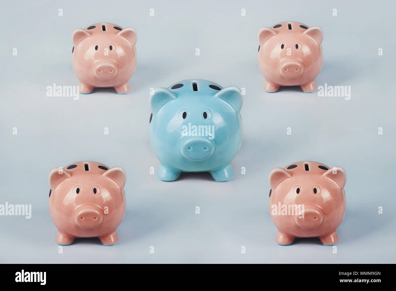 Different colored piggy bank standing out of the crowd. The uniqueness and leadership concept, individuality and difference. Finance and money saving Stock Photo