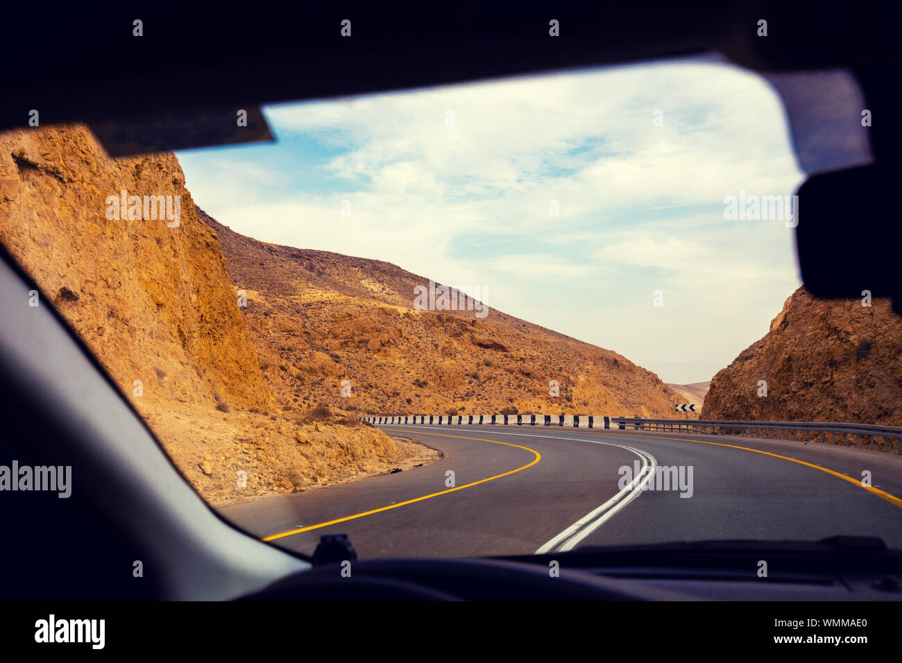 Driving a car on the mountain road in the desert. View of sandstone ...