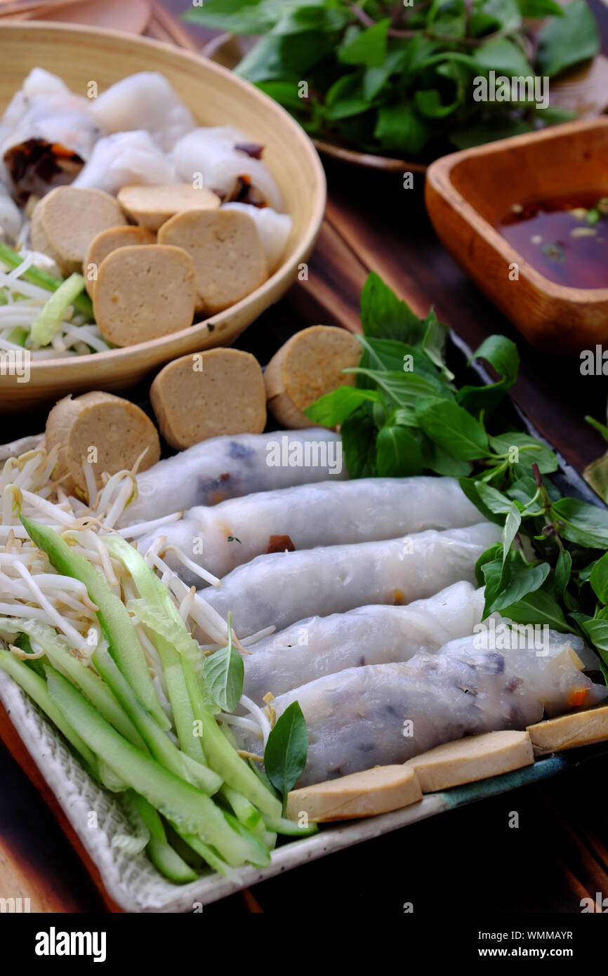 Close up homemade Vietnamese vegan rolled steamed rice pancake or banh cuon  in plate with herb and sauce on wooden background Stock Photo - Alamy