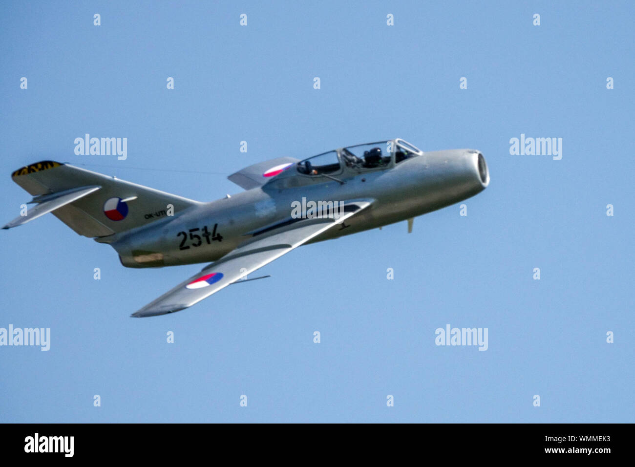 Mig 15 jet fighter in colors of Czechoslovak Air Force, aircraft from the 1950s flying on blue sky Stock Photo
