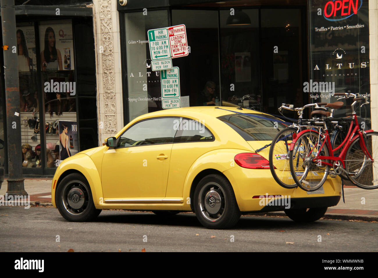 Yellow Volkswagen beetle in the city with bicycles on bike rack Stock Photo  - Alamy