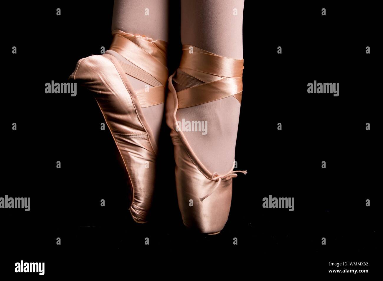 Low Section Of Ballet Dancer Dancing Against Black Background Stock