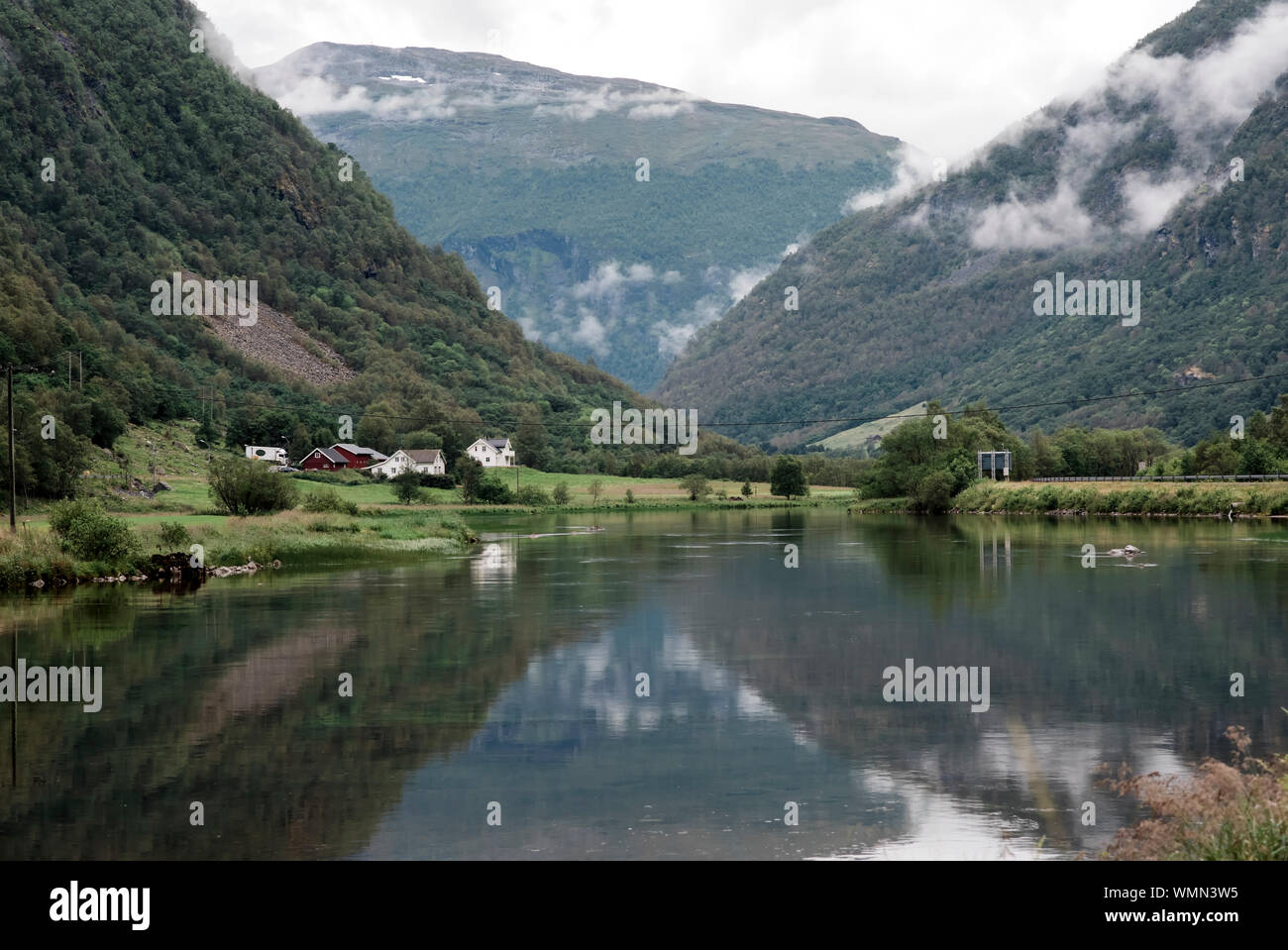 Traditional Nordic houses nessled in a valley of mountains & ocean Stock Photo