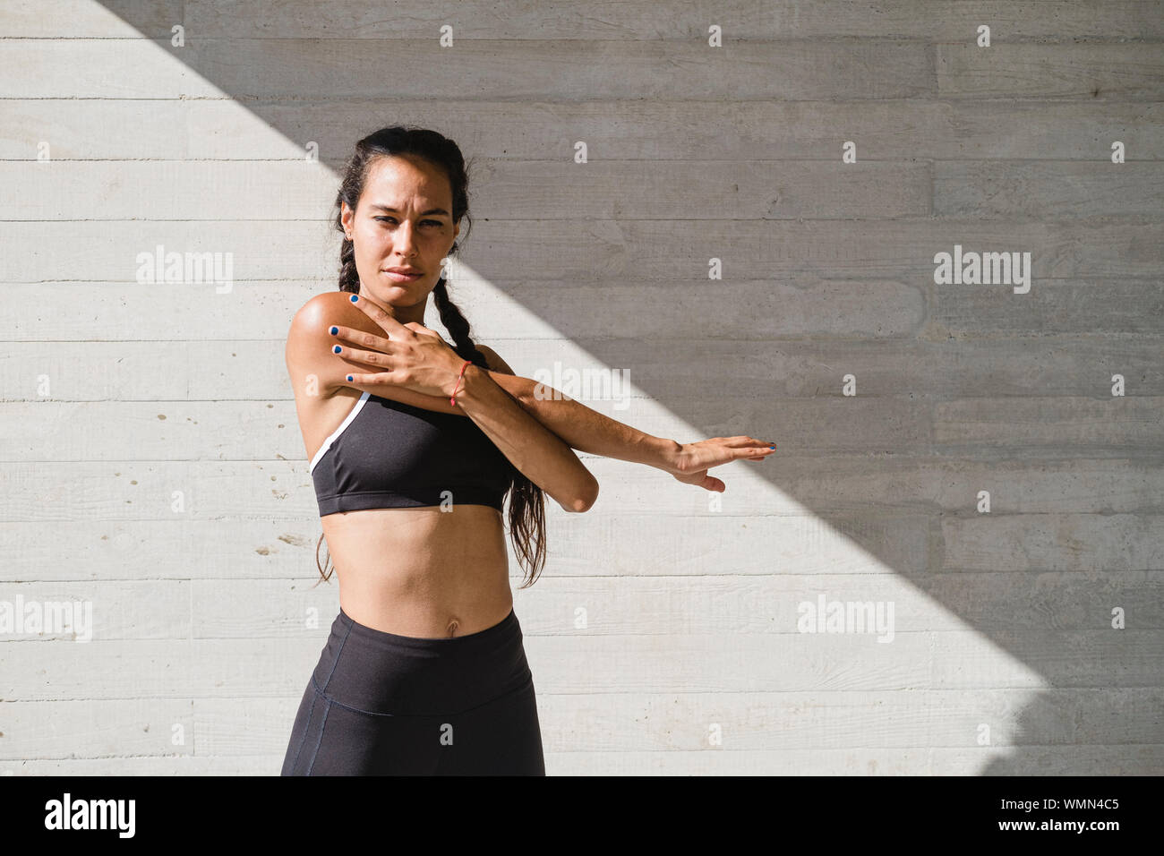 Upper body of female athlete stretching arms Stock Photo