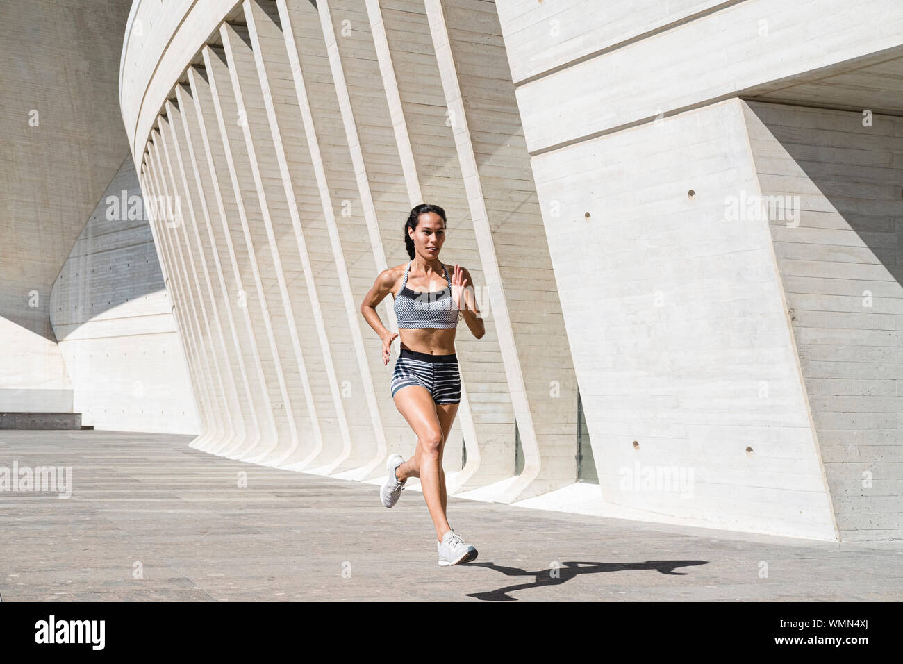 Full body of female athlete in sportswear running on concrete Stock Photo -  Alamy