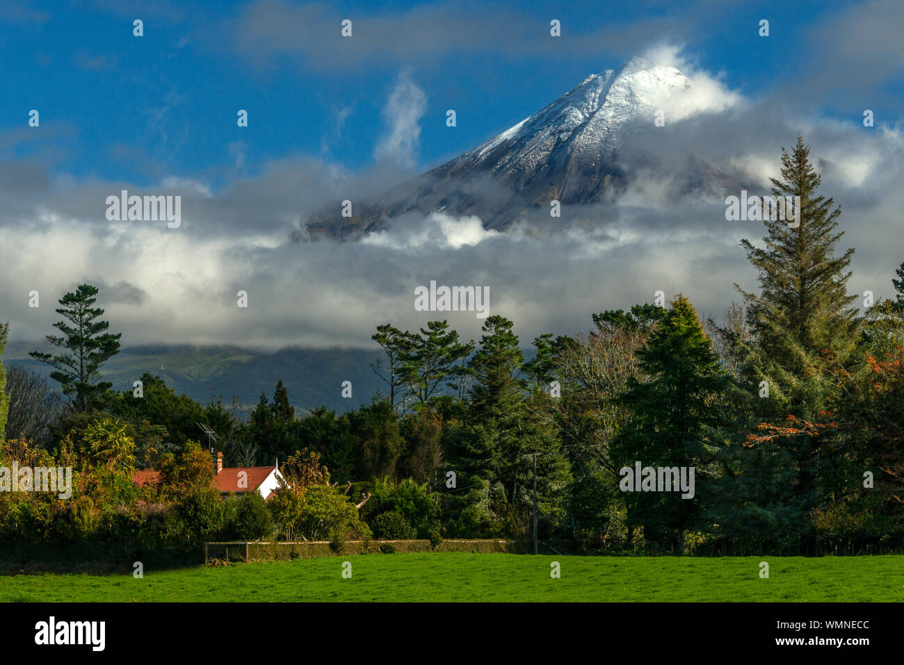 Light snow and whips clouds on the peak of Mt Taranaki (formerly Mt Egmont), a volcano in the north island of New Zealand. Stock Photo