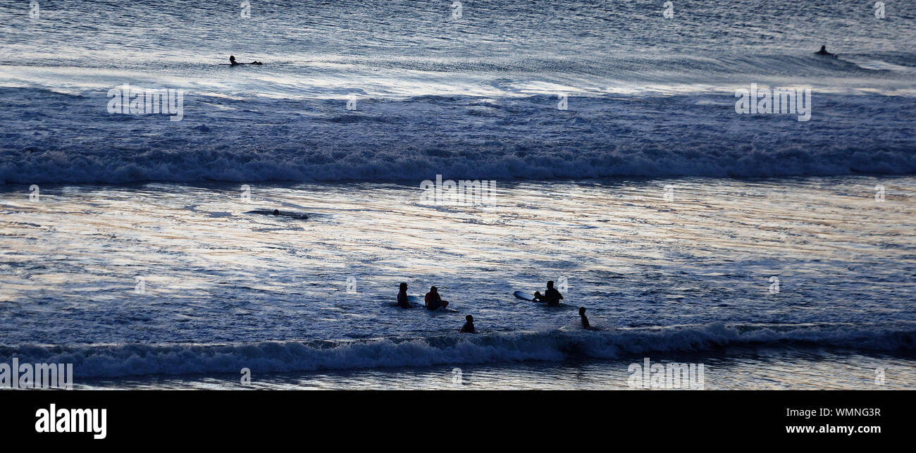 Evening swimmers and suffers at the end of the day Kuta Beach, Bali, Indonesia Stock Photo