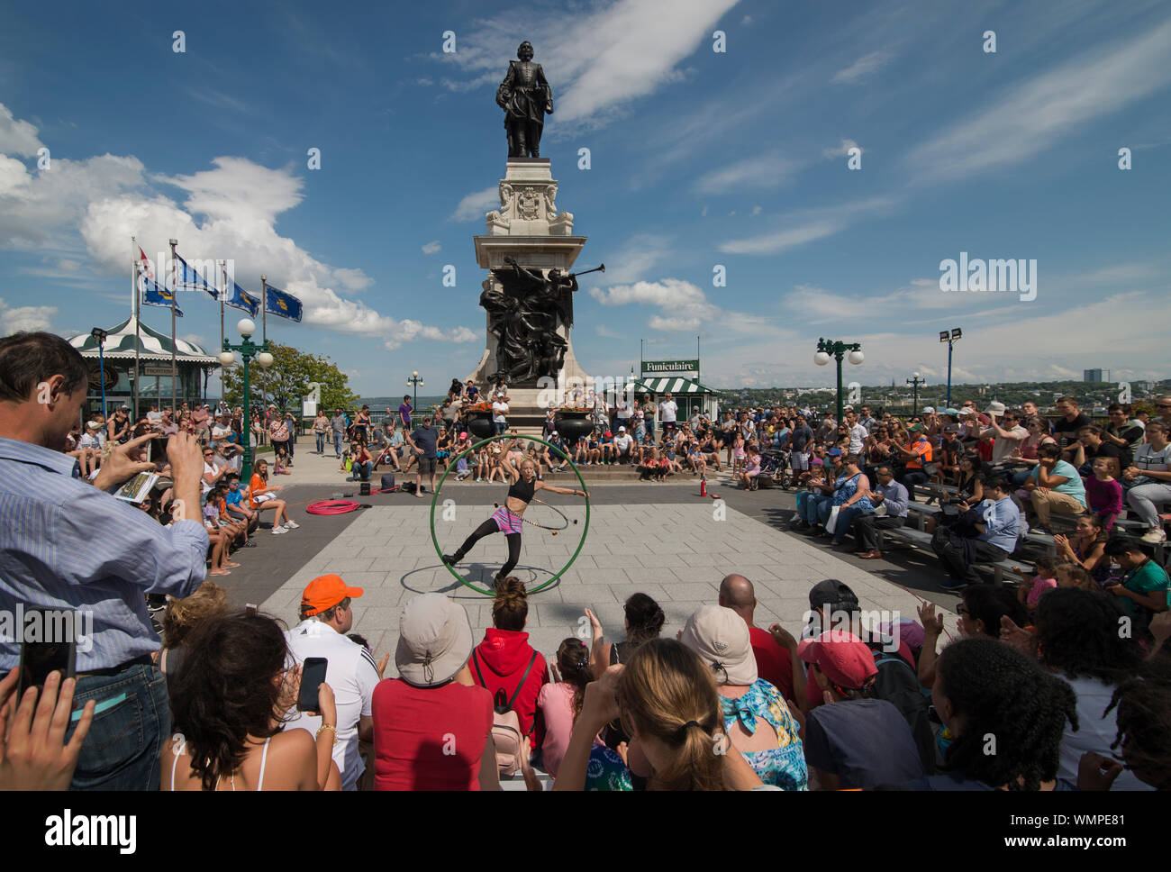 Female acrobat, street performer, plays to a large crowd on a summer afternoon on the Terrasse Dufferin in central Quebec, CA. Stock Photo