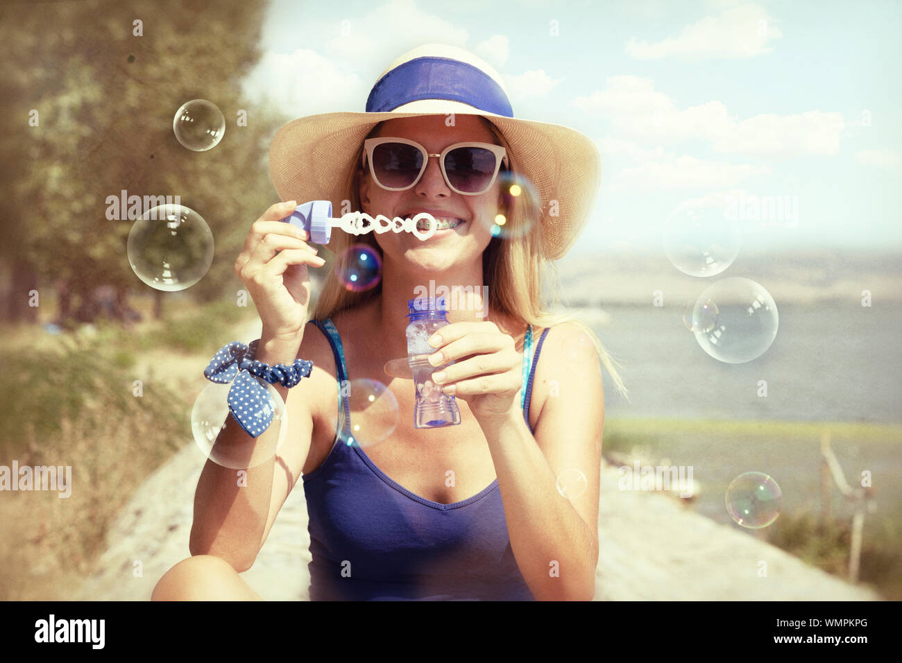 Young woman blowing soap bubbles in a park Stock Photo