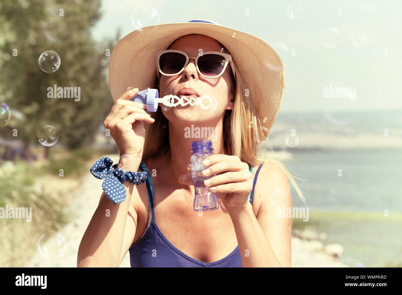 Young woman blowing soap bubbles in a park Stock Photo