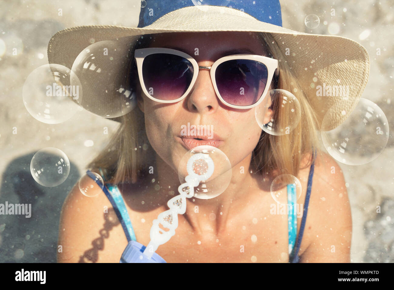 Young woman blowing soap bubbles in a park Stock Photo