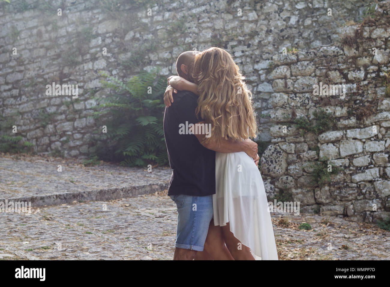 Dating couple hugging standing in castle park on summer day Stock Photo