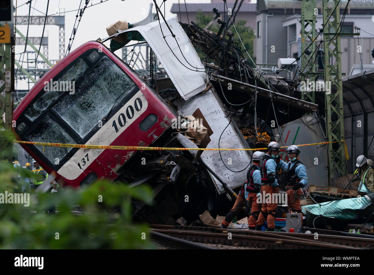 Fire brigade and policemen at the Kanagawa-Shinmachi station in Yokohama, Japan.A train collided with a truck that was stuck at the railroad crossing and at least 33 people were injured and one person died. Stock Photo