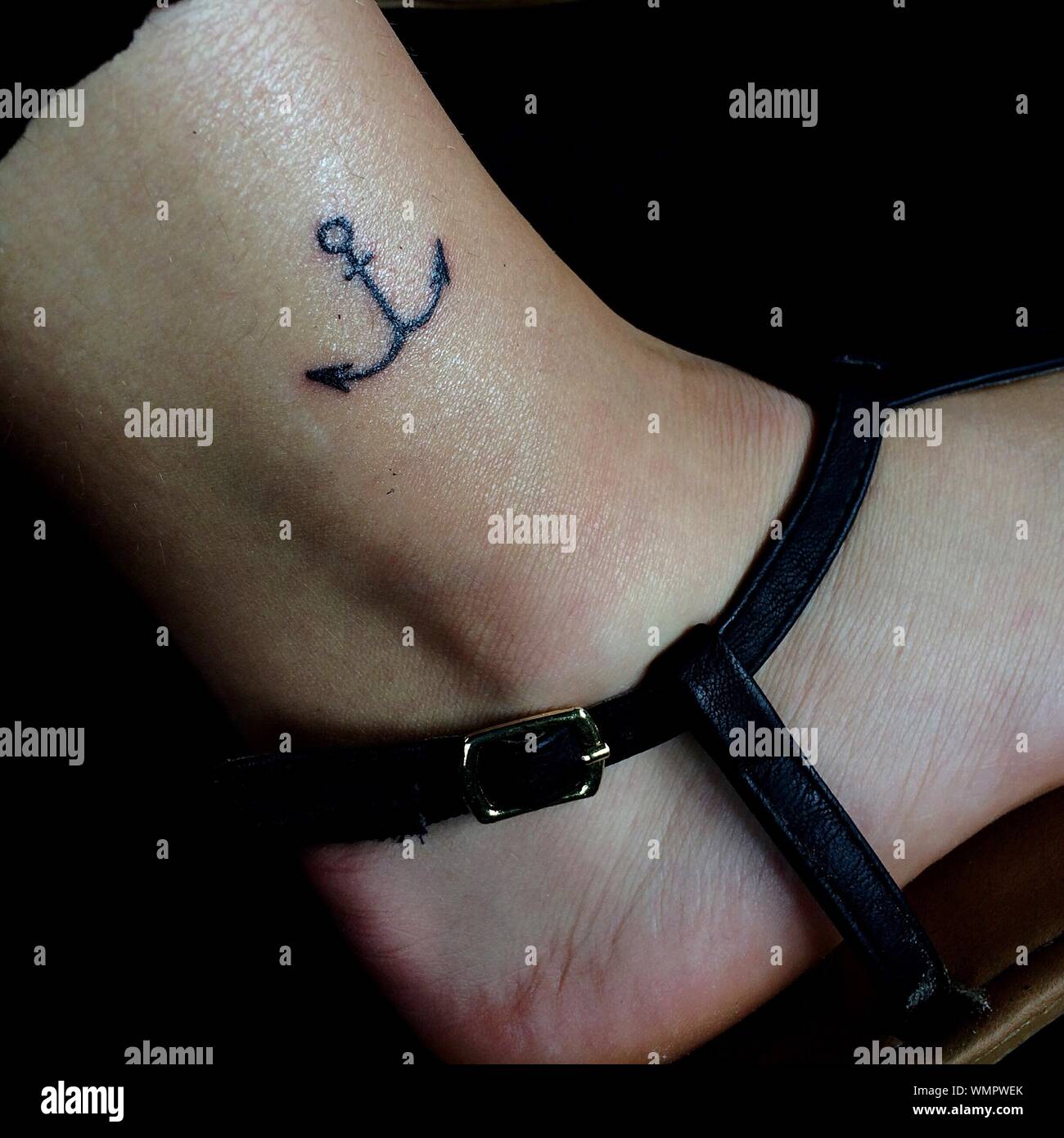Cropped Image Of Woman Leg With Anchor Tattoo Wearing Sandal Stock Photo Alamy