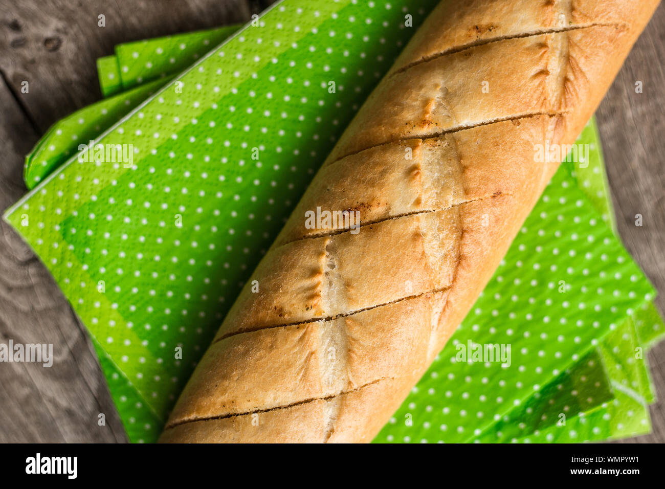 Sliced long french bread over wooden table. Baguette. Restaurant Stock Photo