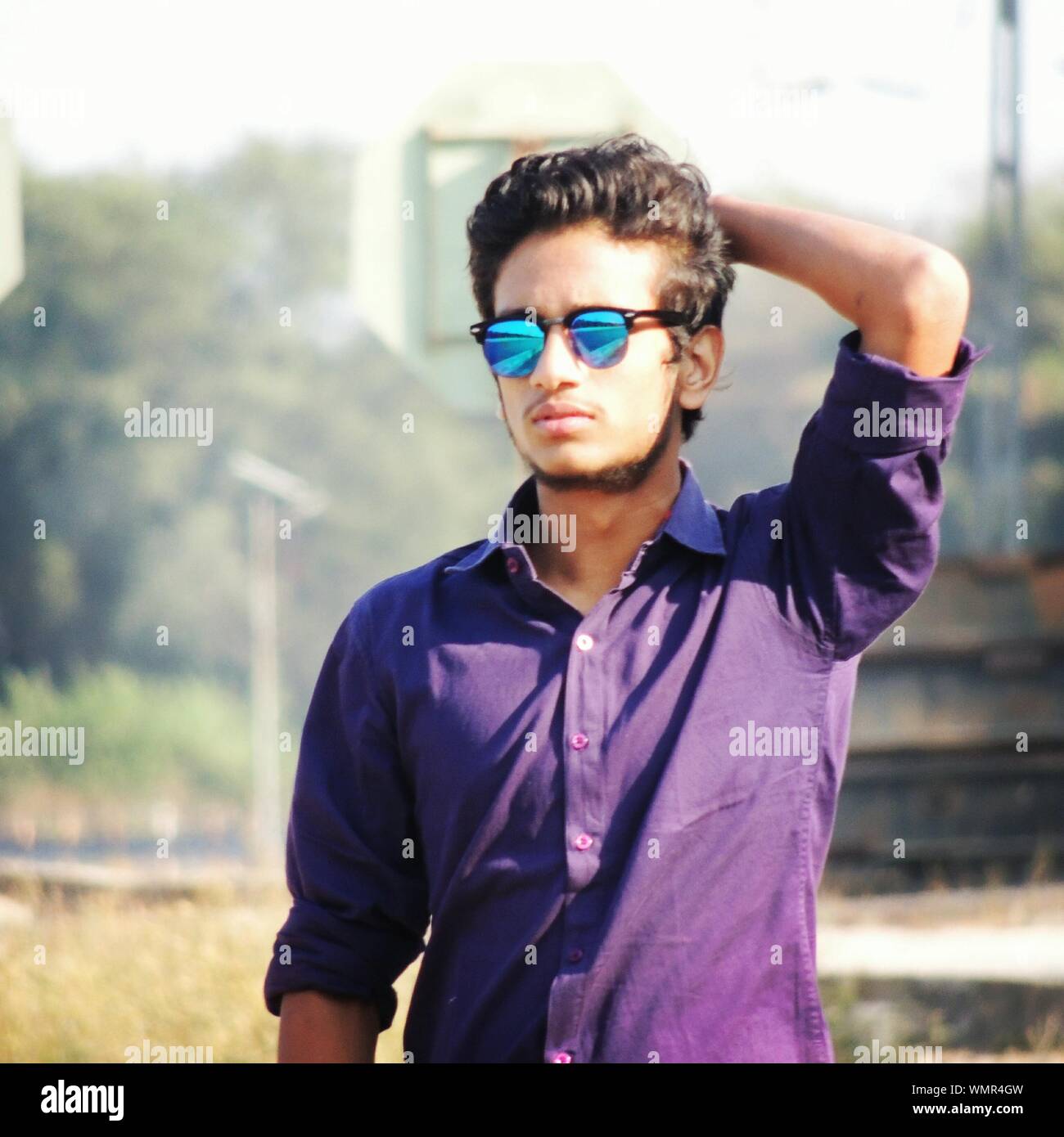 Young Man Wearing Sunglasses With Hand In Hair Standing On Field Stock Photo - Alamy Young Man Wearing Sunglasses With Hand In Hair Standing On Field Stock Photo - Alamy