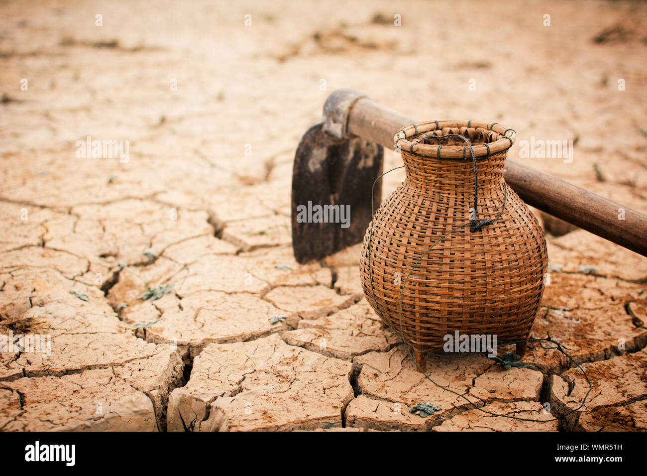 Close-up Of Garden Hoe And Basket On Barren Land Stock Photo