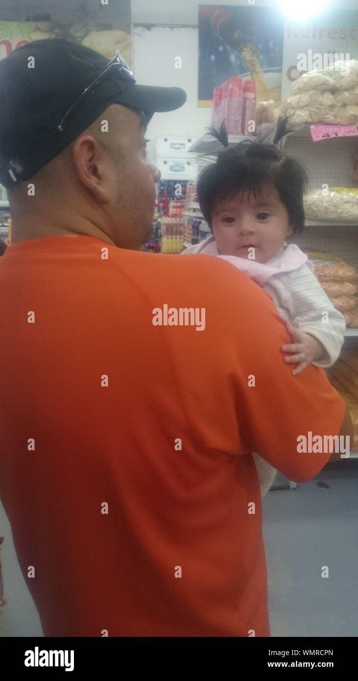Rear View Of Father Carrying Daughter At Super Market Stock Photo