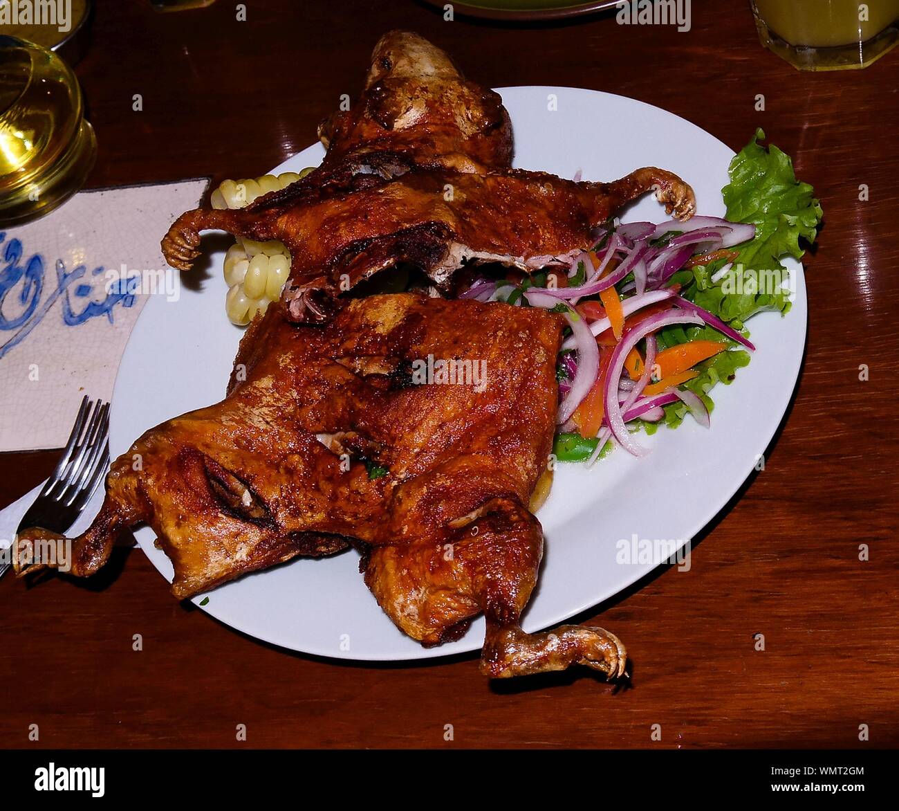 Close-up view to grilled cuy aka Guinea pig, Traditional peruvian dish with salad Arequipa, Peru Stock Photo