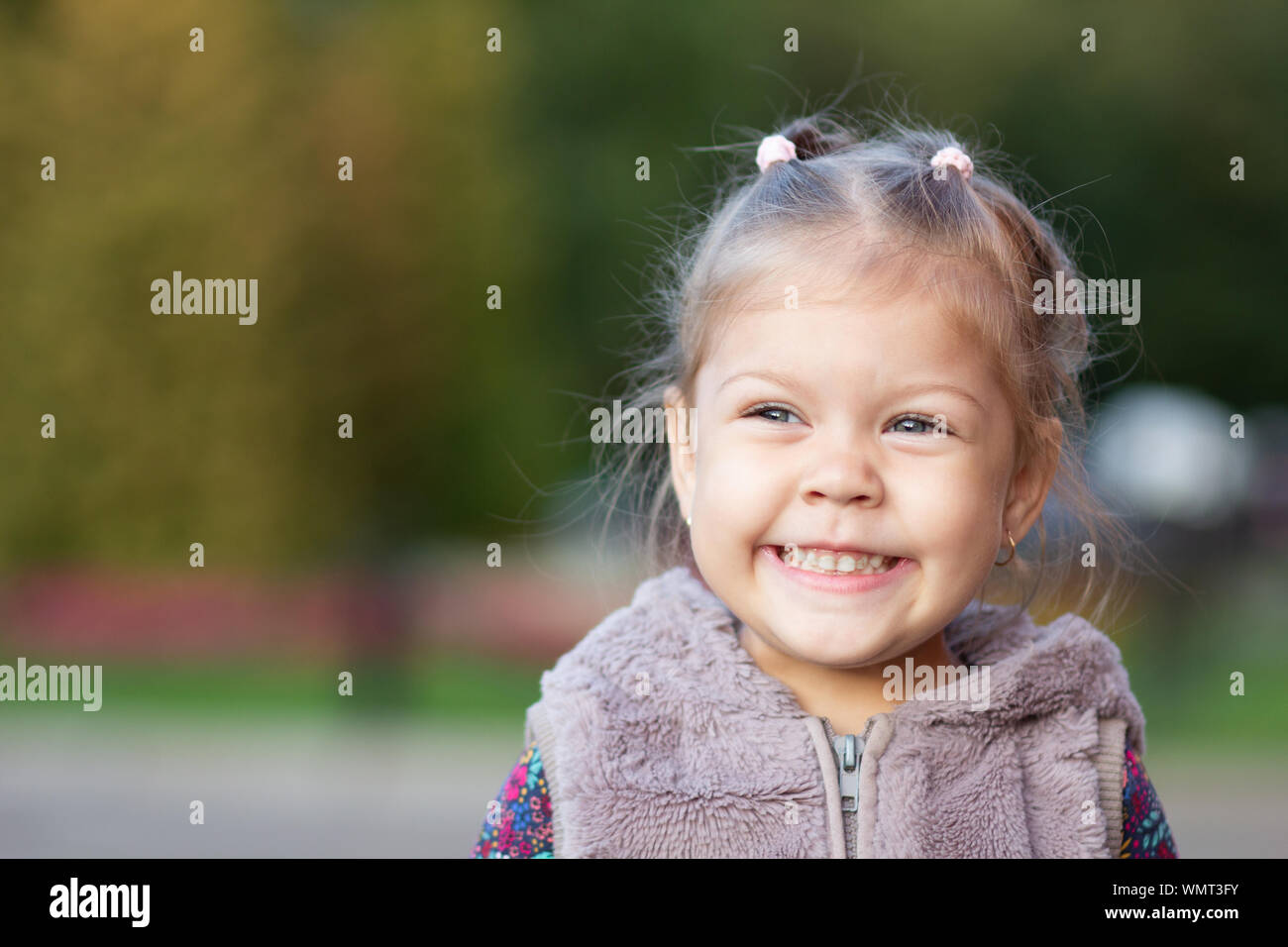 Portrait of smiling little girl looking aside Stock Photo - Alamy