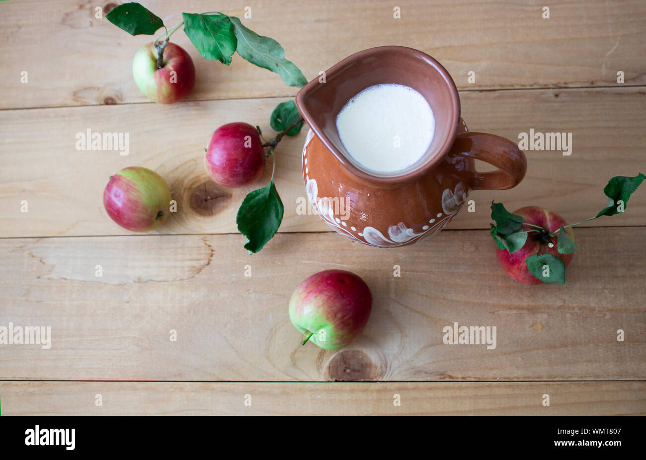 Tasty fresh milk is one of the main sources of nutrition. Milk and apples rustic food. On a wooden background. View from above. copyspace Stock Photo