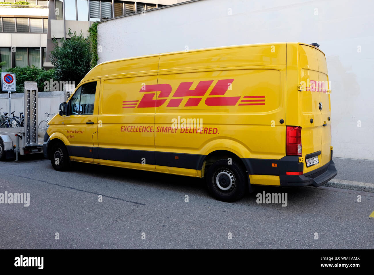 A parked DHL delivery van in Basel, Switzerland Stock Photo