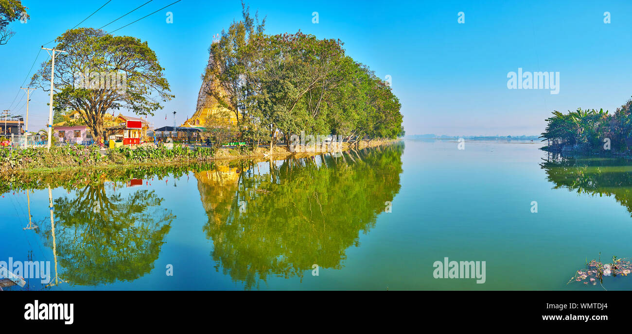Panorama of hazy Tharzi Pond, lined with spread green trees, gardens, temples and houses of Nyaungshwe, Myanmar Stock Photo