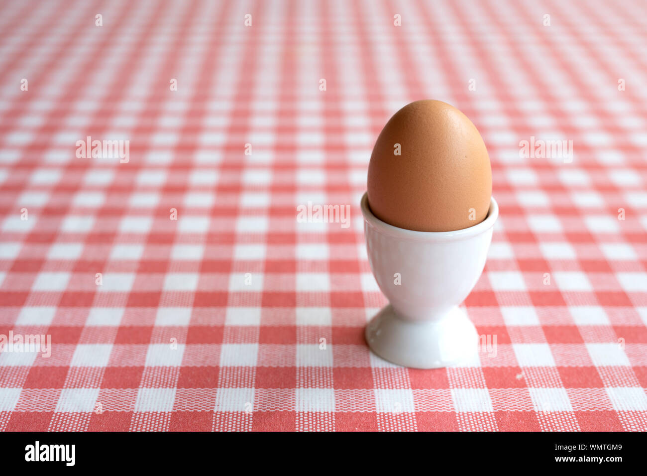 Single boiled egg in egg cup on table Stock Photo Alamy