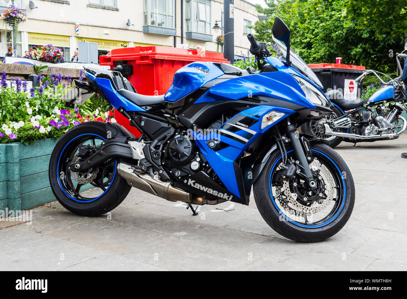 650 cc Kawasaki Ninja motorcycle in blue parked in front of a street flower display during the 2019 Calne Bike meet Stock Photo