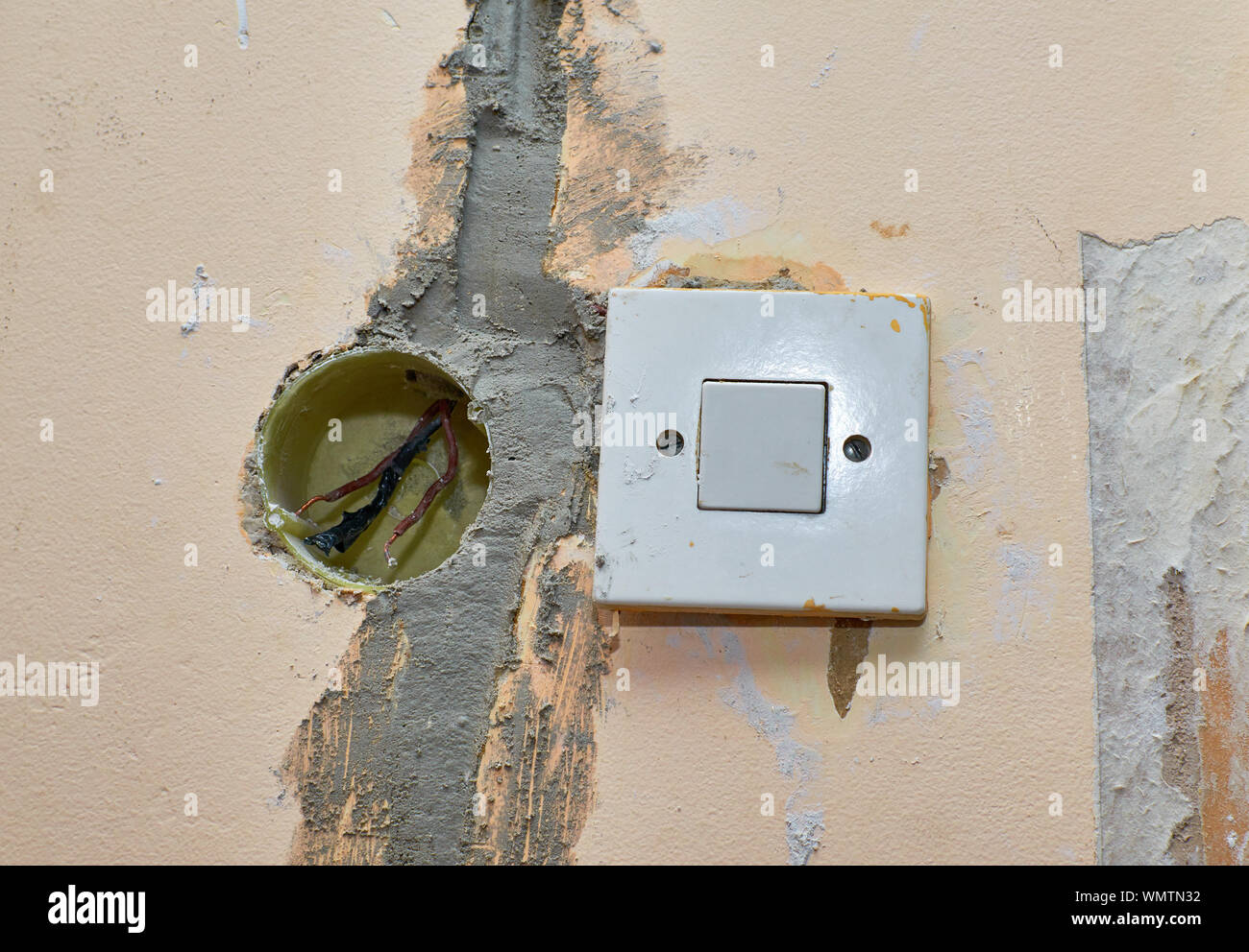 Box with electric wires next to an old light switchers during renovation works in an apartment Stock Photo