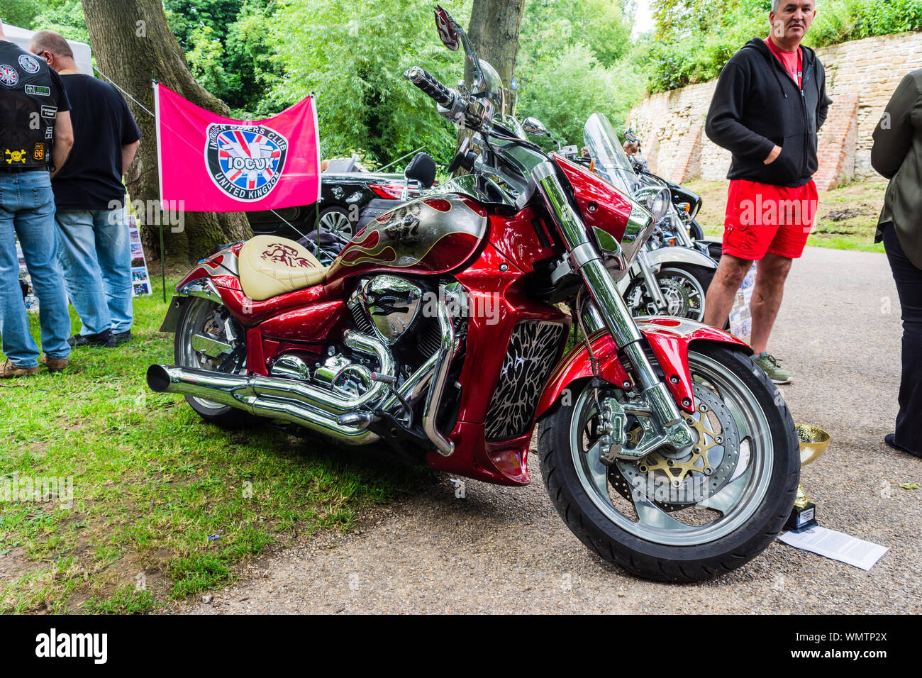 A customized red Suzuki Intruder motorcycle in front of a banner promoting  Intruder Owners Club at the 2019 Calne Bike meet Stock Photo - Alamy