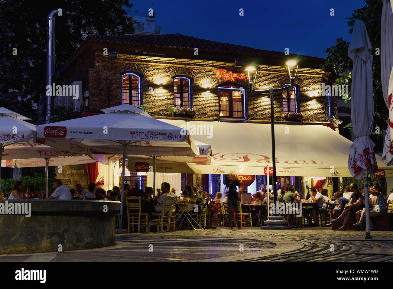 Thessaloniki, Greece Ladadika area with crowd & live bouzouki music on a tavern. Night view of