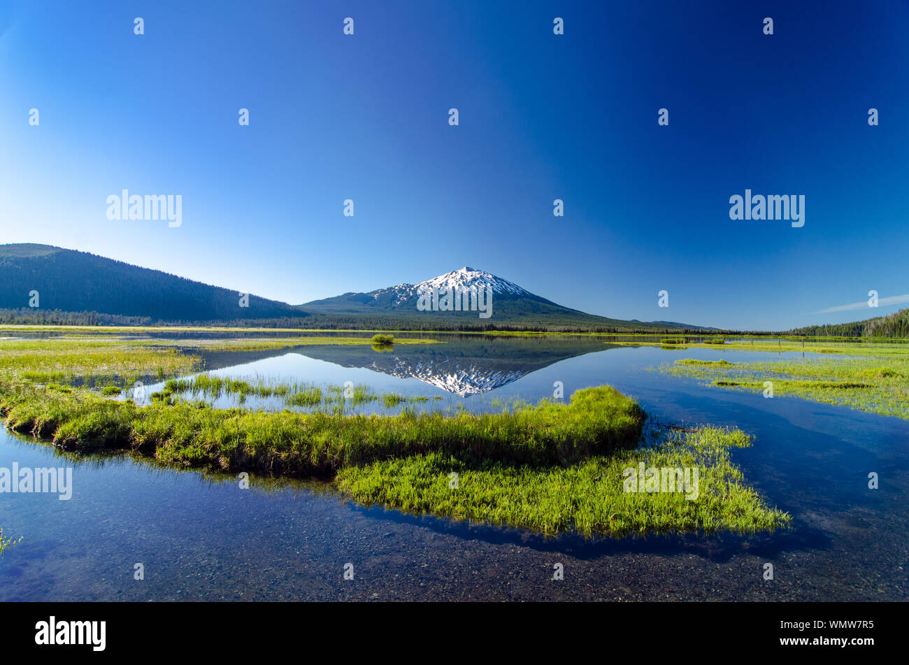 Scenic View Of Mt Bachelor And Sparks Lake Against Clear Blue Sky Stock Photo