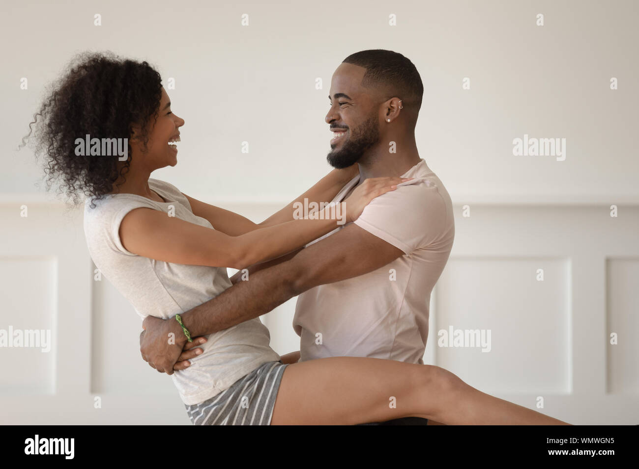 Happy african american man holding joyful smiling wife. Stock Photo