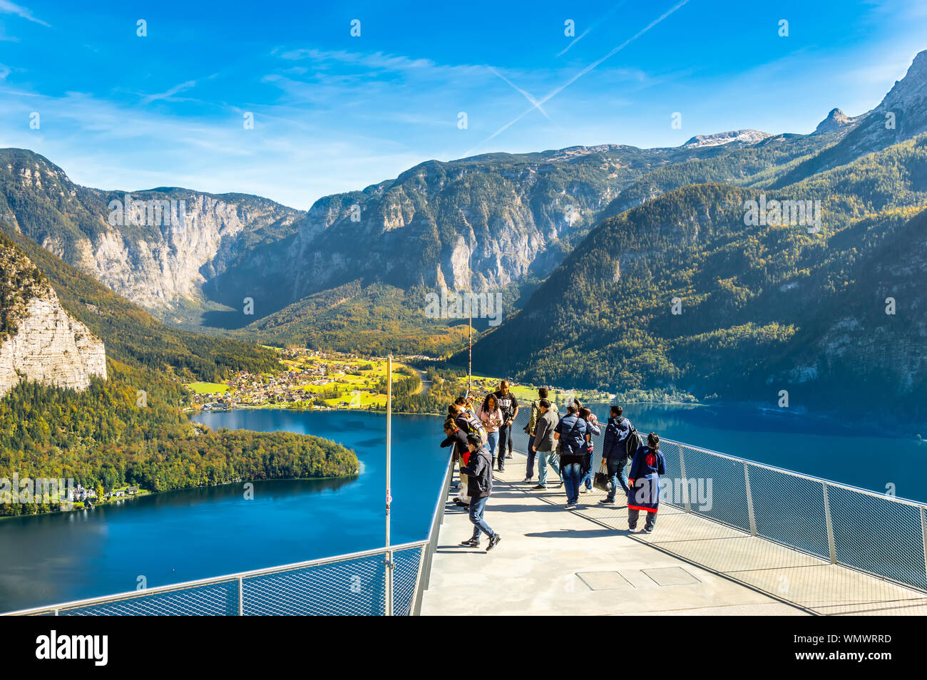 Hallstatt, Austria - OCT 2018: Tourists take photos and enjoy the view of the mountains and lake Hallstatter See from the World Heritage View Point. Stock Photo