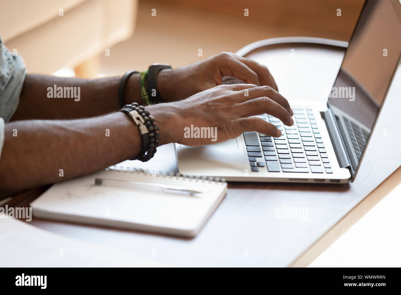 Close up cropped image young black man using laptop. Stock Photo