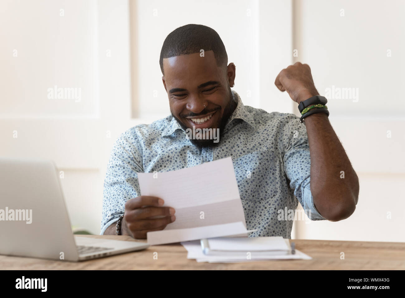 Happy african american guy received banking loan approval. Stock Photo