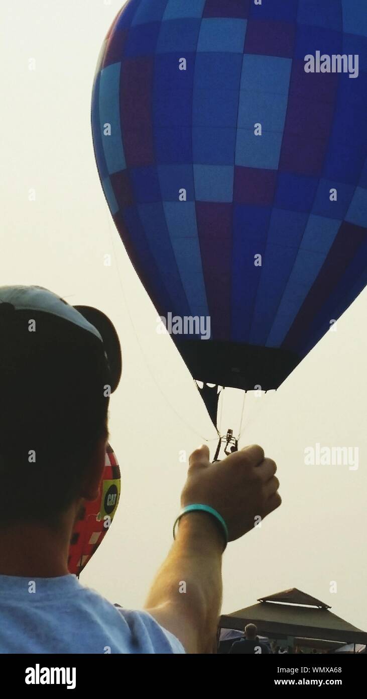Optical Illusion Of Man Holding Hot Air Balloon Against Clear Sky Stock Photo Alamy Optical Illusion Of Man Holding Hot Air Balloon Against Clear Sky Stock Photo Alamy