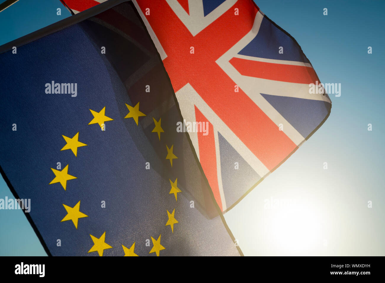European Union and British Union Jack flag flying together in front of bright blue sky as the UK takes steps towards Brexit, leaving the EU Stock Photo