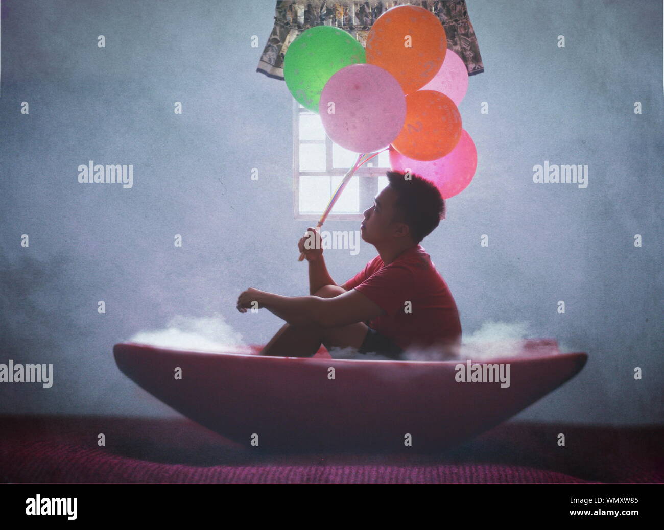 Optical Illusion Of Man Holding Balloon Sitting In Bowl Against Wall Stock Photo Alamy Optical Illusion Of Man Holding Balloon Sitting In Bowl Against Wall Stock Photo Alamy