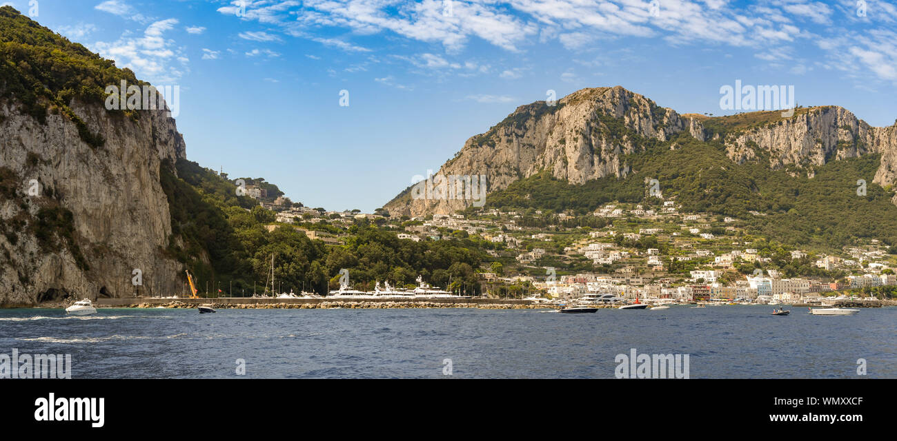 ISLE OF CAPRI, ITALY - AUGUST 2019: Panoramic view of the port on the island of Capri with mountains behind. Stock Photo