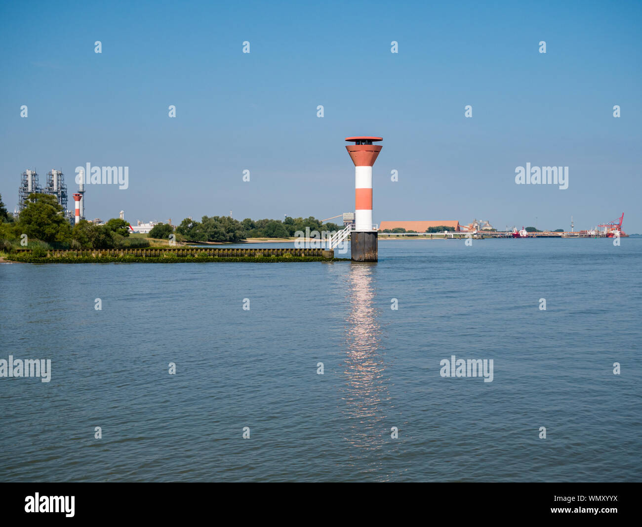 Stadersand, Germany - August 25, 2019: View from jetty Stadersand at lighthouse and Radar station. DOW Chemical and BUSS Terminal at small town of Bue Stock Photo