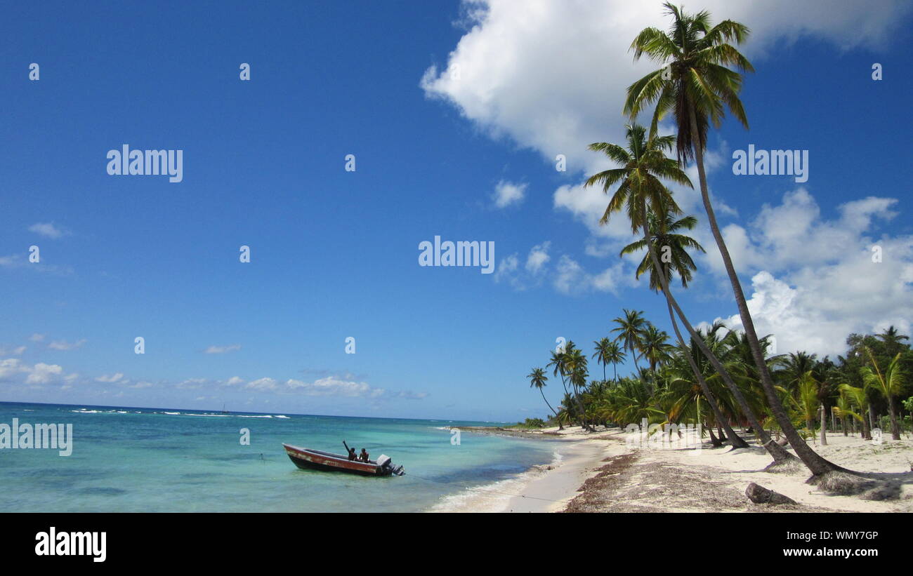 Scenic View Of Fishermen On Boat In Tropics Against Cloudy Sky Stock Photo