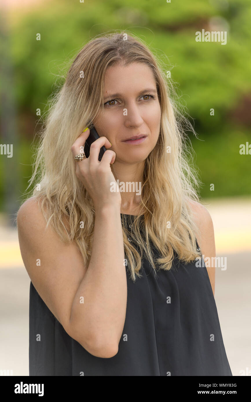 Worried woman receiving bad news over the phone Stock Photo