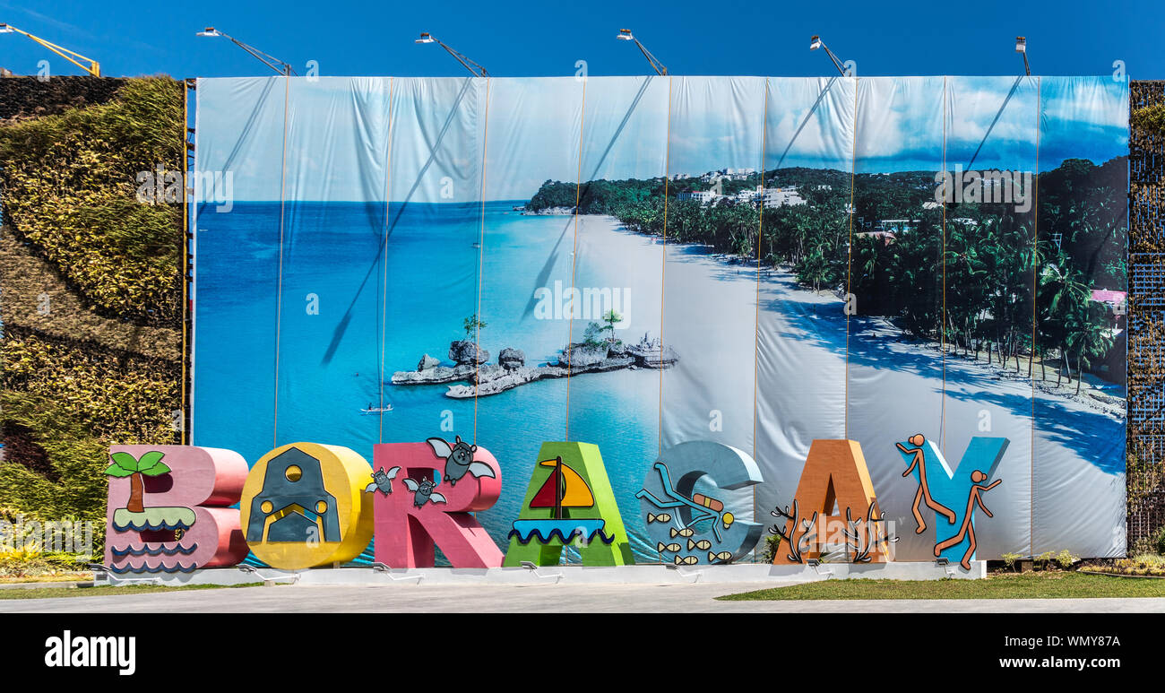 Manoc-Manoc, Boracay, Philippines - March 4, 2019: Colorful giant tourist welcome sign spelling out the name set against photo banner of sandy beach. Stock Photo