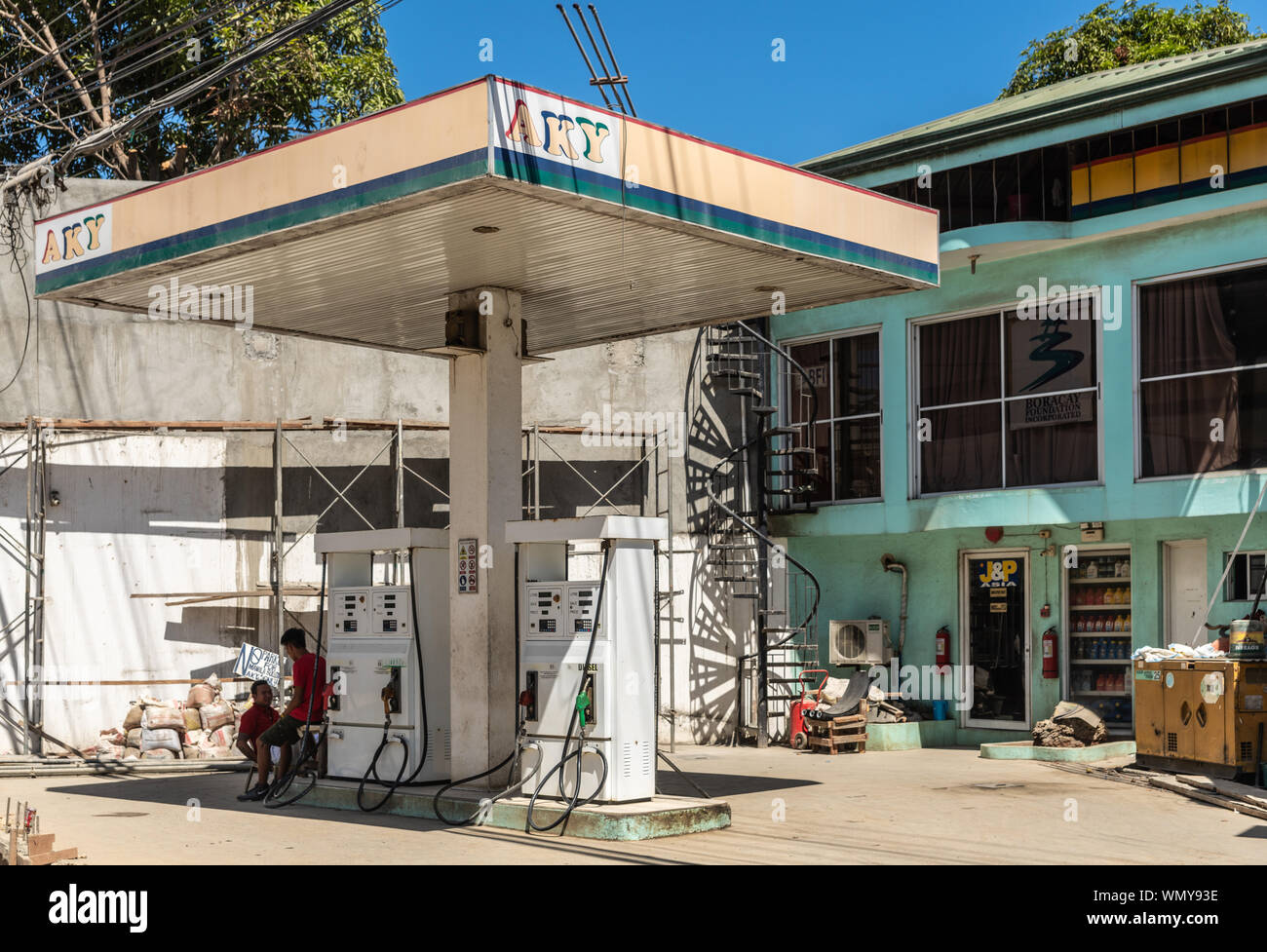 Manoc-Manoc, Boracay, Philippines - March 4, 2019: Small AKY gas station with mechanicla service building in back. Two servers wait for customers. Blu Stock Photo