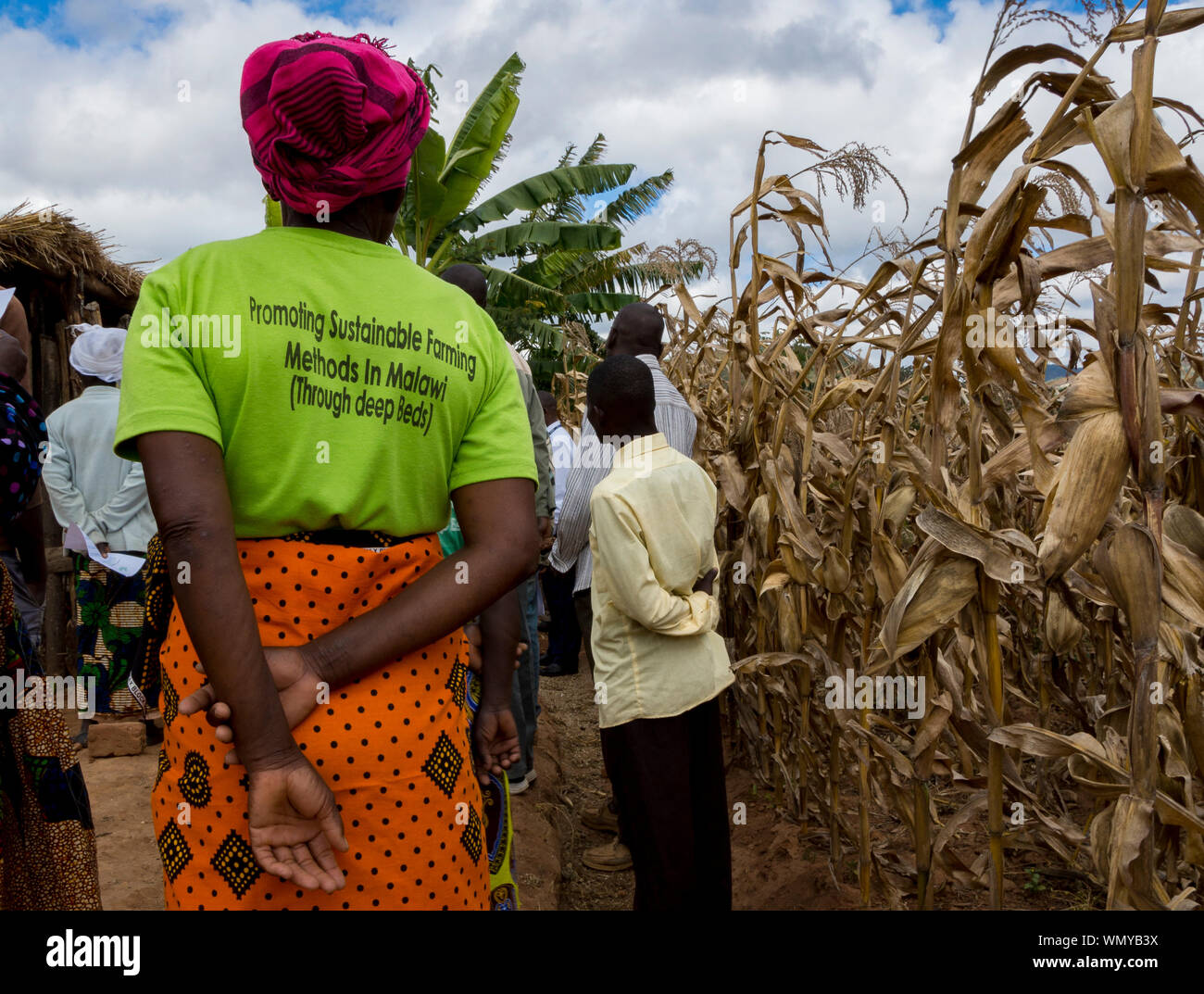 Women farmer with t-shirt promoting Tiyeni charity's sustainable deep-bed cultivation technique (conservation agriculture) in Malawi. Stock Photo