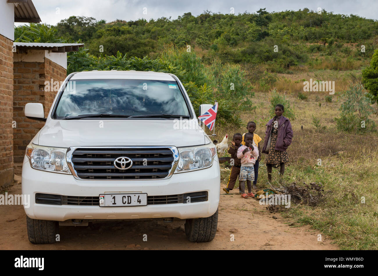 Malawian children stand by the British High Commissioner's Toyota Landcruiser during a field visit to agricultural areas near Mzuzu, Malawi. Stock Photo