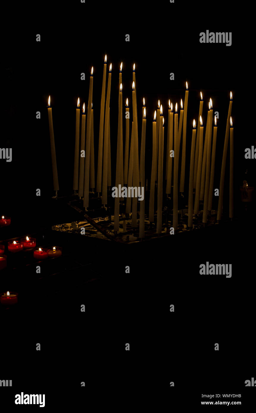 Many burning candles with black background Stock Photo - Alamy